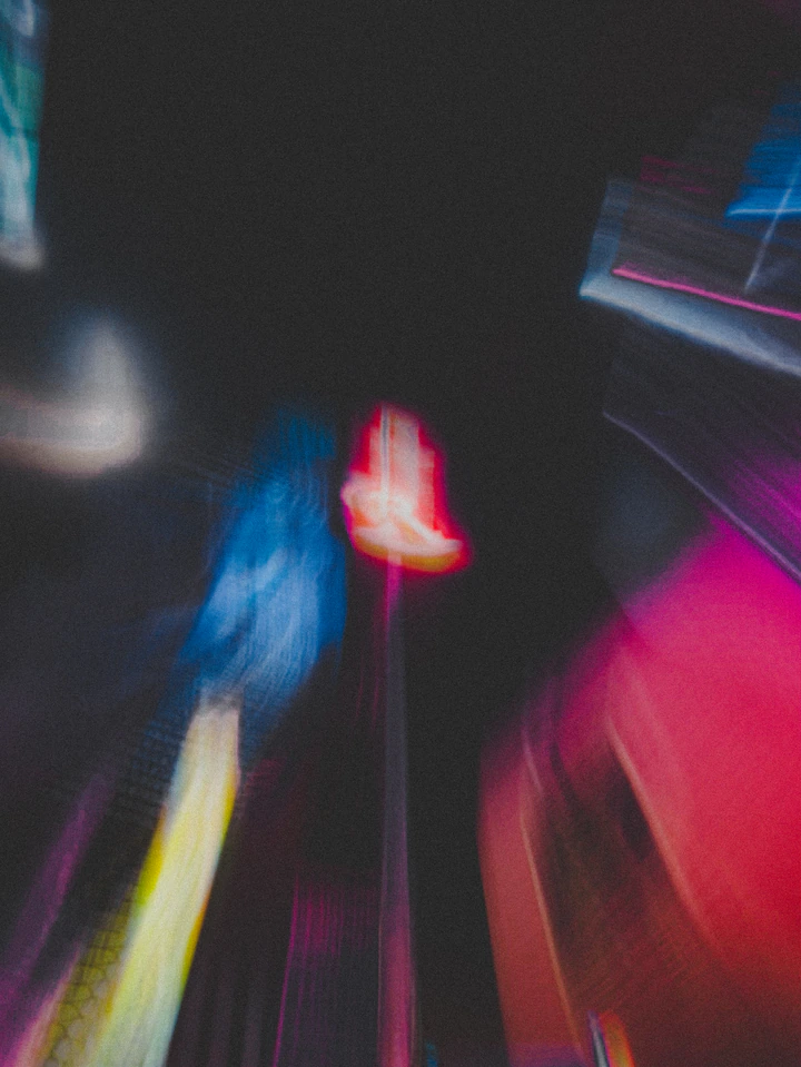 A neon sign blurred into streaks of color at night